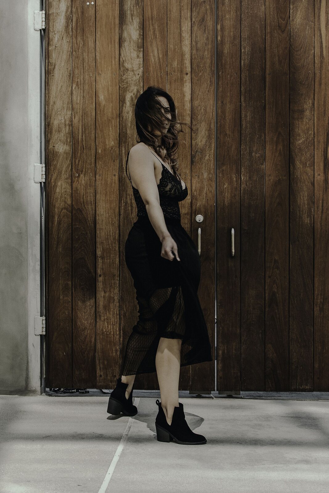 Woman in a black dress and black ankle boots